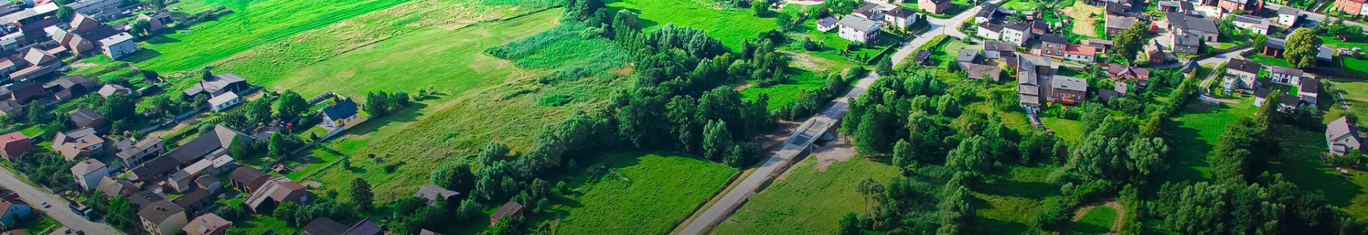 Baner wizerunkowy top Gminy Boron&oacute;w, widok z g&oacute;ry na łąki i zabudowania